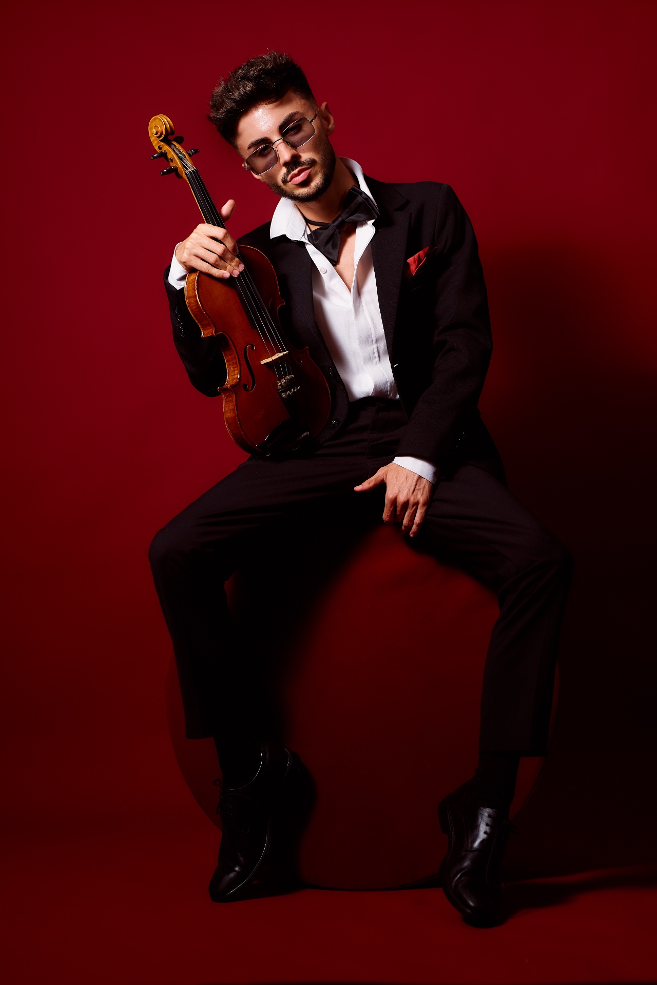 Máté Kozma seated with violin